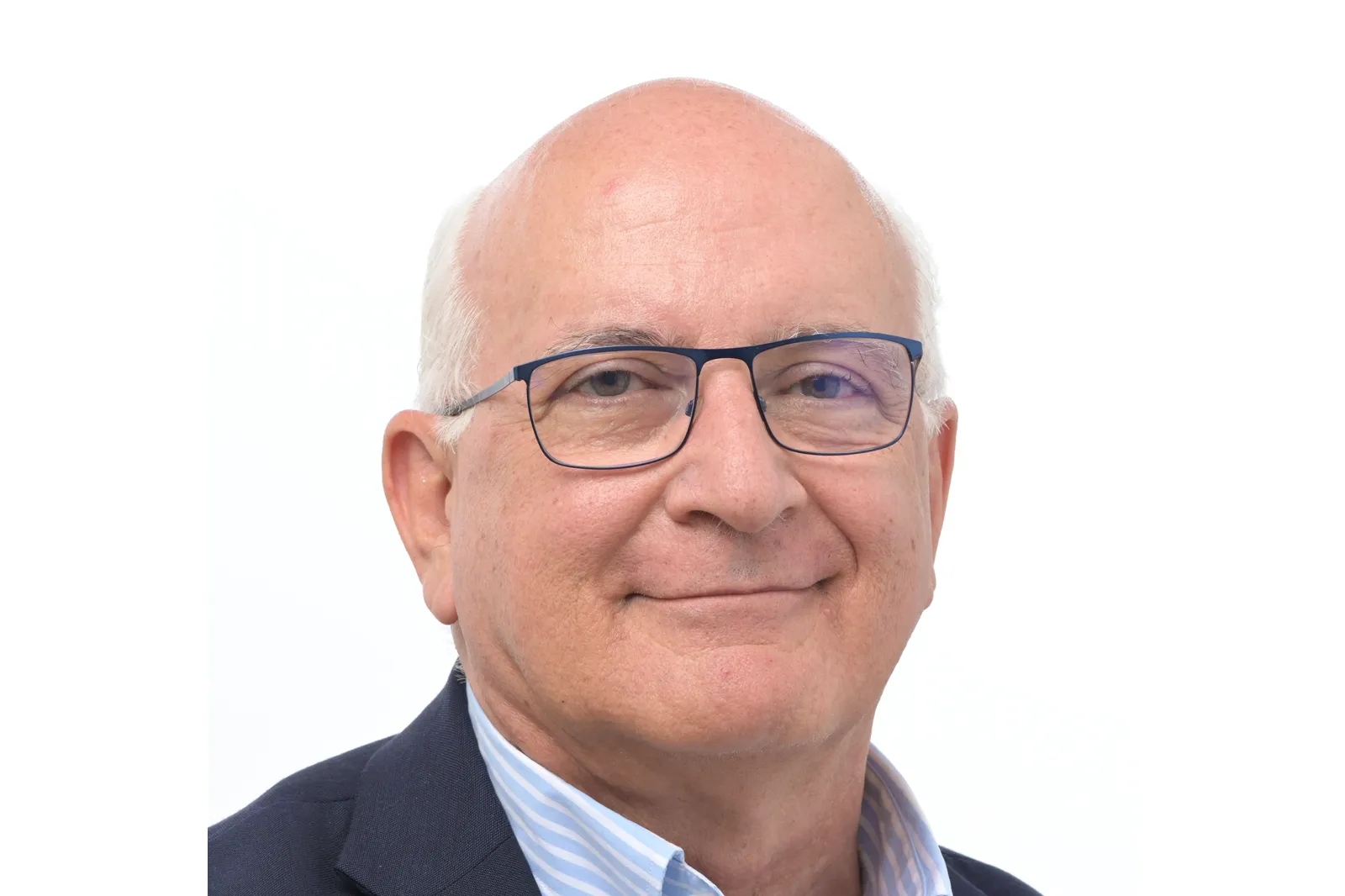 Retrato oficial del eurodiputado Javier Zarzalejos: hombre mayor, calvo, con gafas de montura azul, camisa de rayas y chaqueta azul marino, sobre fondo blanco.