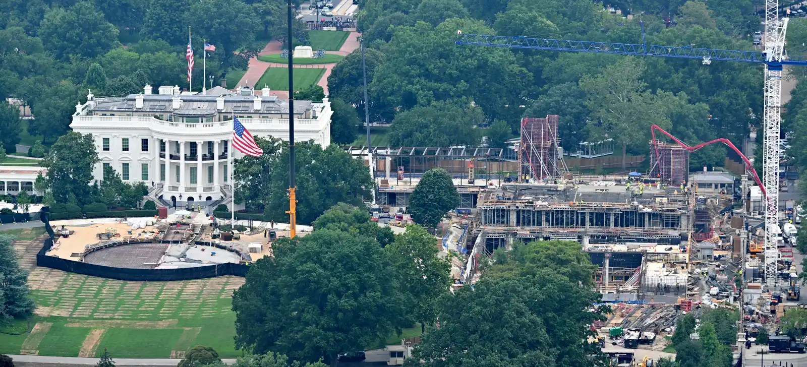 Vista aérea de la Casa Blanca y, a su derecha, el solar del antiguo ala este convertido en obra: estructuras de hormigón, encofrados, grúas y operarios con chaleco reflectante entre los árboles del President's Park.