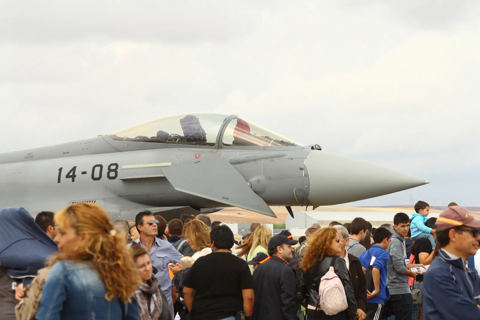 Un caza Eurofighter Typhoon gris del Ejército del Aire español volando con el tren de aterrizaje replegado sobre un cielo despejado.