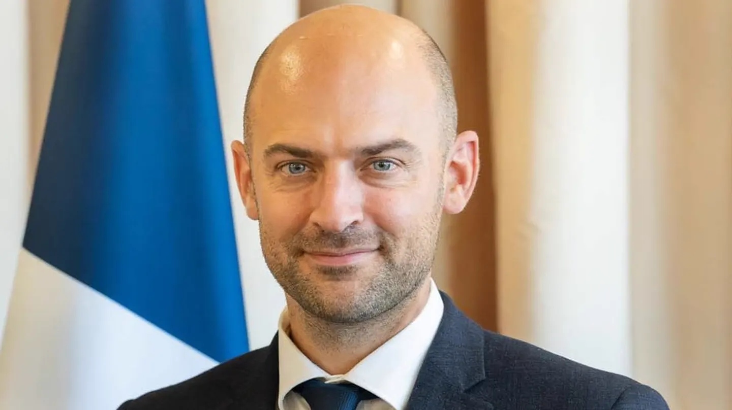 Retrato oficial de Jean-Noël Barrot, ministro francés de Europa y Asuntos Exteriores, con una bandera de Francia a su espalda