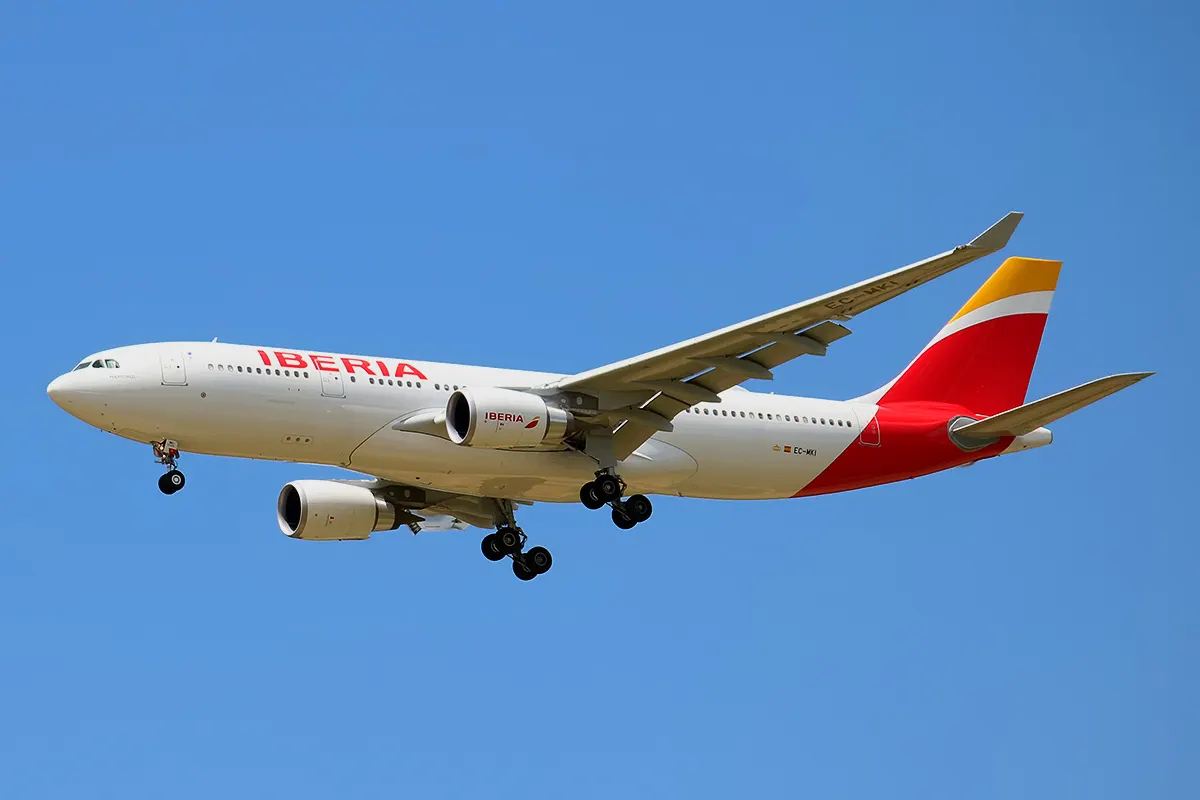 Avión Airbus A330-200 de Iberia en vuelo con el tren de aterrizaje desplegado sobre un cielo azul