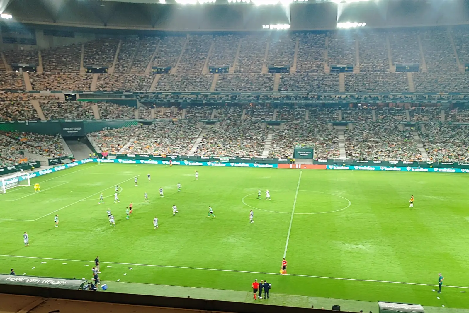 Vista general del Estadio de La Cartuja lleno de público durante un Betis-Real Sociedad de noche, con el juego repartido por el centro del campo bajo los focos