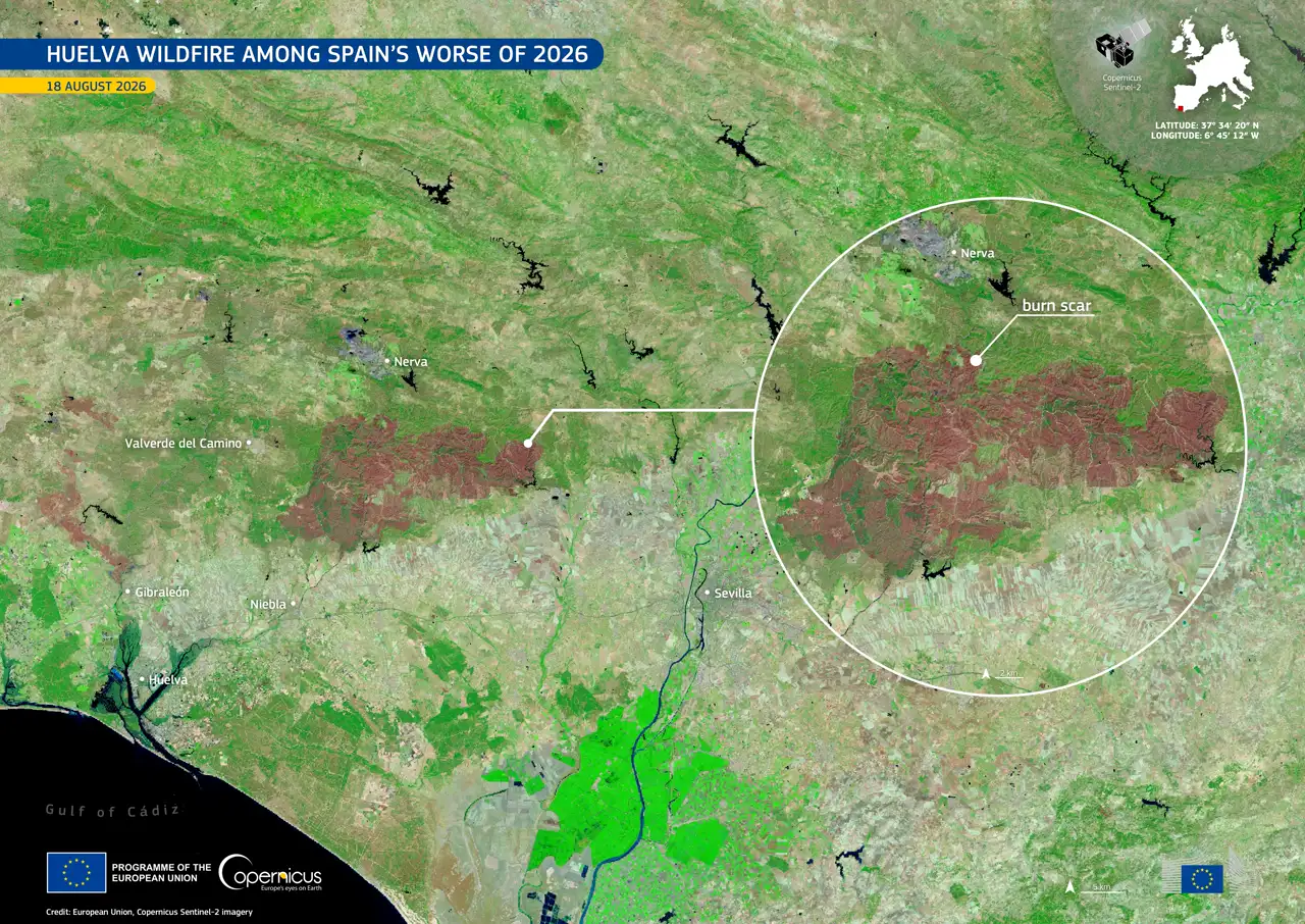 Imagen de satélite en falso color del suroeste de Andalucía, desde el golfo de Cádiz hasta Sevilla. La vegetación sana aparece en verde intenso y una gran mancha rojiza y marrón, alargada de este a oeste entre Valverde del Camino y Nerva, marca la superficie quemada. Un círculo ampliado a la derecha señala esa cicatriz con la etiqueta «burn scar». Abajo, los logotipos de la Unión Europea y del programa Copernicus.