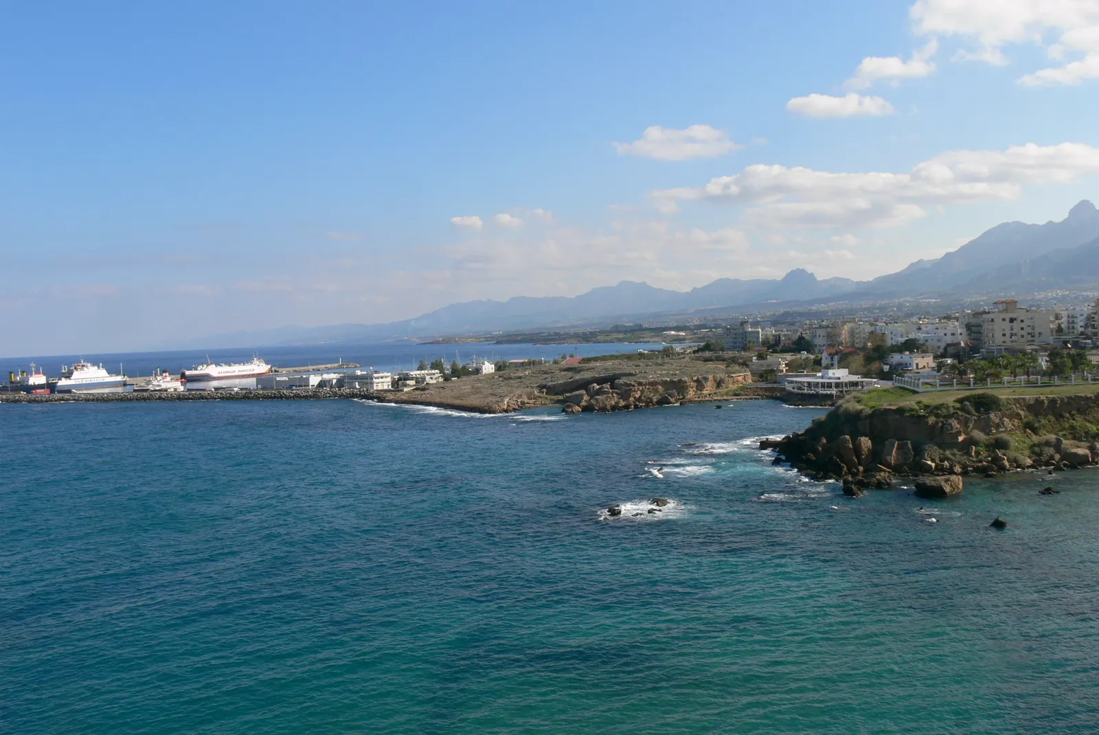 Vista aérea del puerto nuevo de Kirenia, en el norte de Chipre, con varios ferris blancos atracados junto al espigón y la cordillera al fondo
