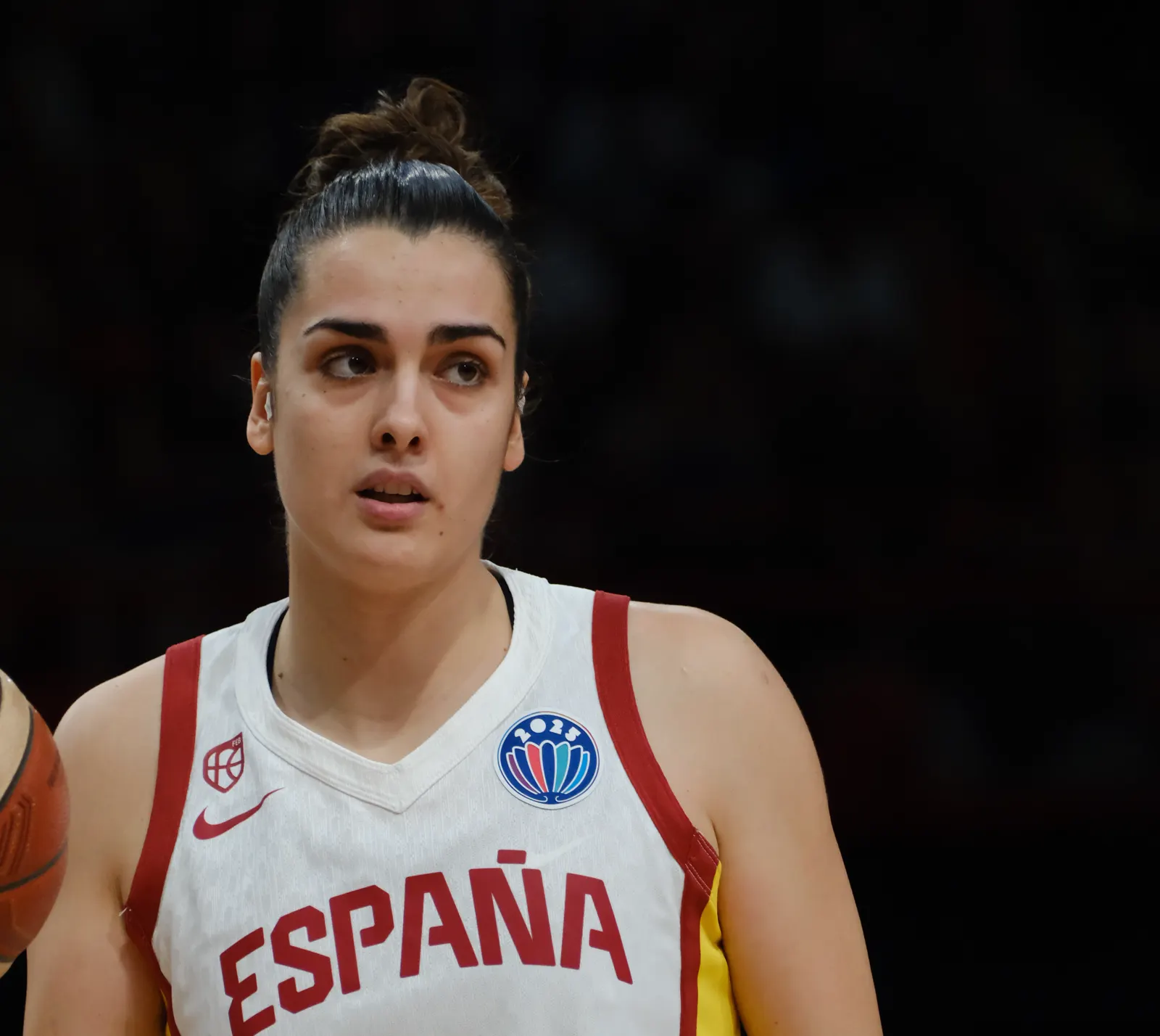 Paula Ginzo, con la camiseta blanca de España y el dorsal 20, sujeta un balón de baloncesto durante un partido