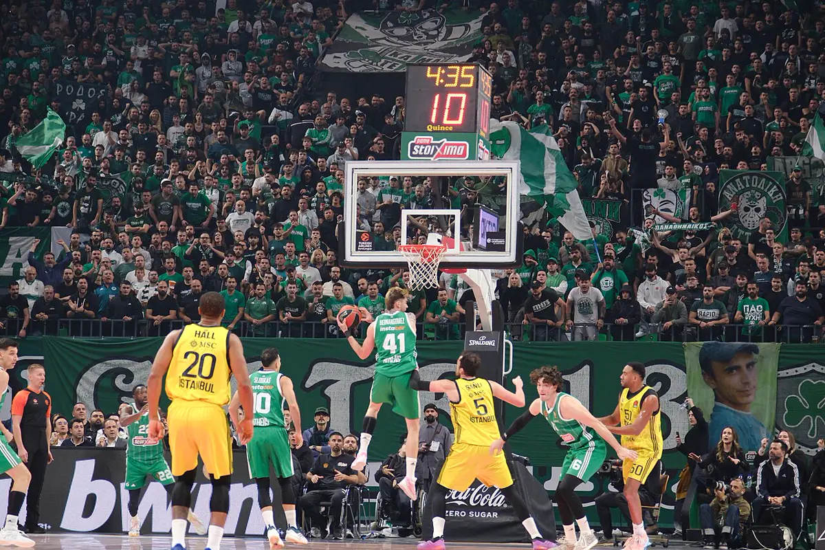 Juancho Hernangómez, con el dorsal 41 y camiseta verde del Panathinaikos, salta hacia el aro ante rivales de amarillo en un pabellón lleno de aficionados de verde