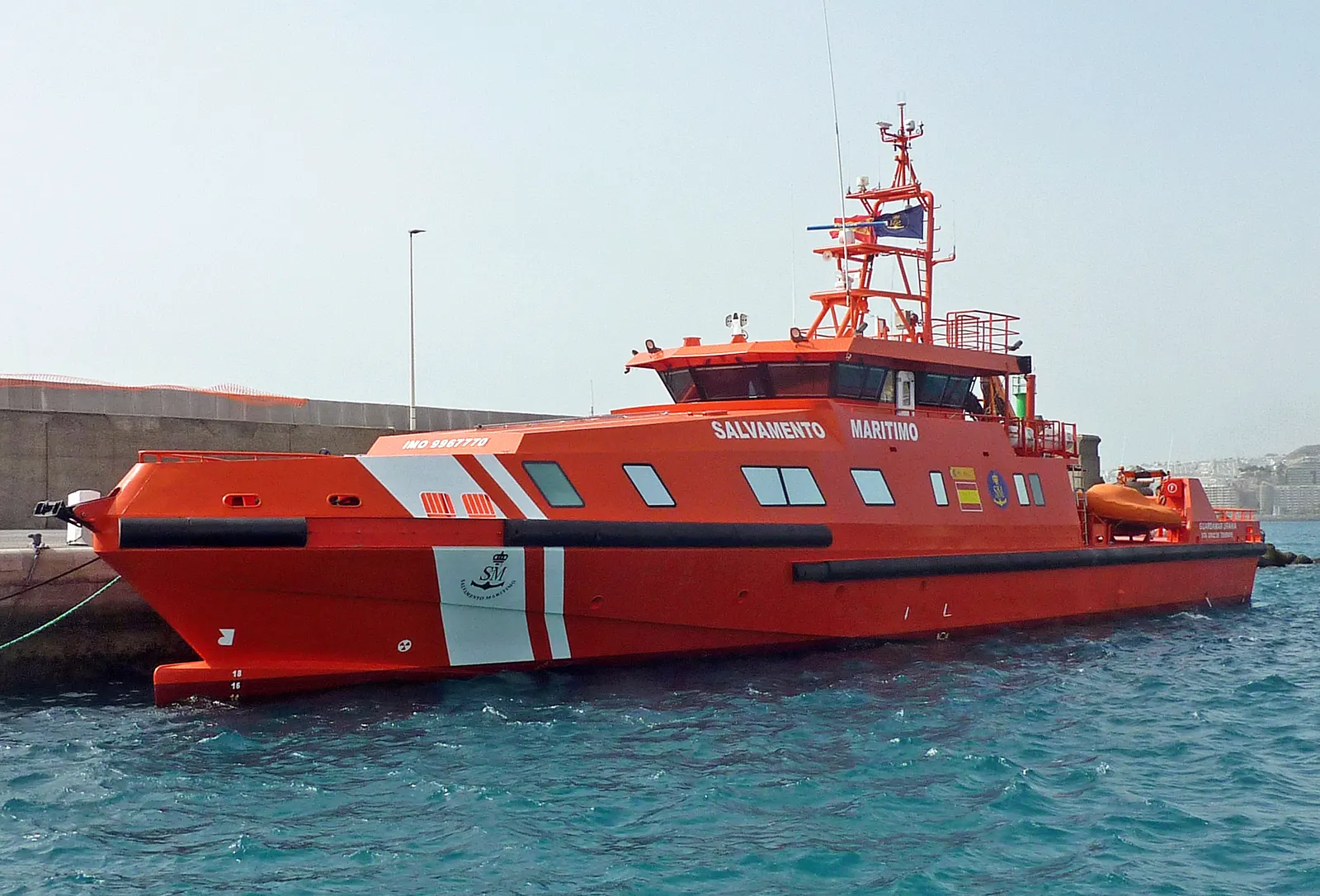 El buque de salvamento Guardamar Urania, de casco naranja con la leyenda «Salvamento Marítimo», amarrado en el muelle de Arguineguín (Gran Canaria).