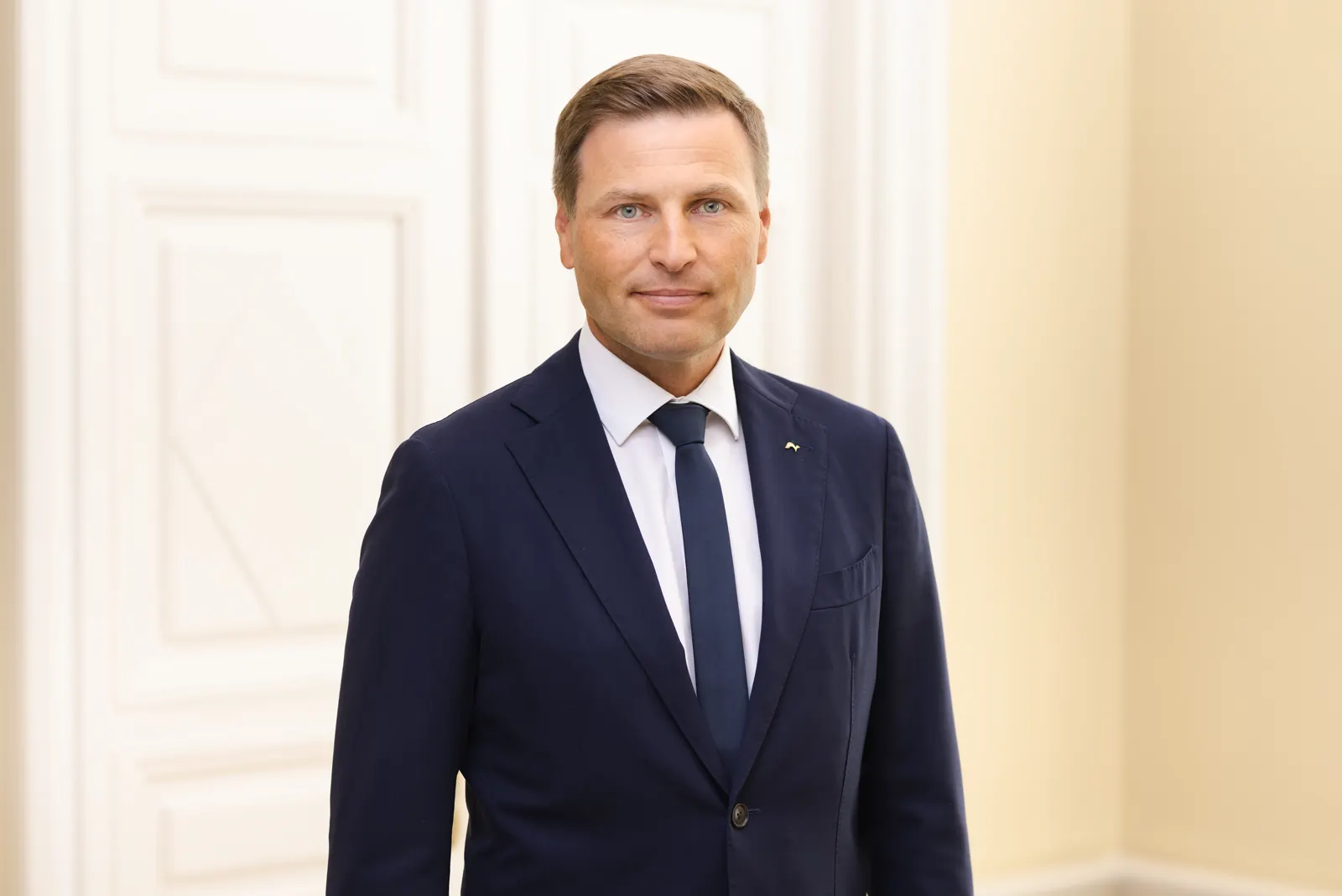 Retrato de Hanno Pevkur, de traje azul oscuro y corbata, ante una pared clara con molduras